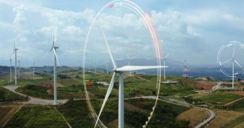 Aerial view of windmills with digitally generated holographic display tech data visualization. Wind power turbines generating clean renewable energy for sustainable development in a green ecologic way