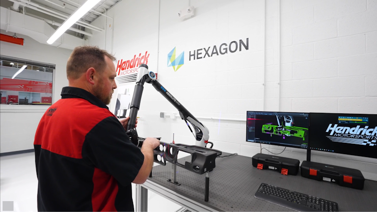 An engineer uses the Hexagon AS1 Scanner and a portable CMM to measure a car part