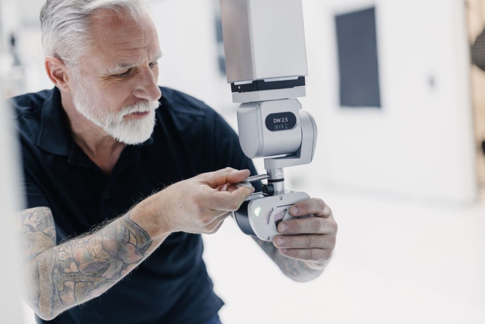 a metrology engineer makes some adjustments to the measuring head of a CMM
